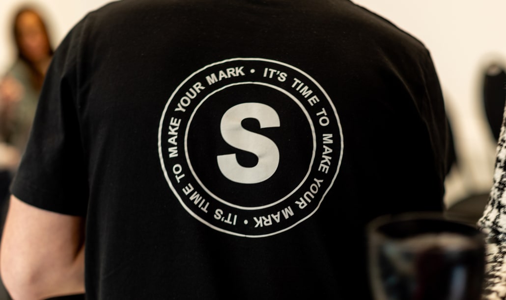 Squibble team member wearing branded T-shirt with company slogan, highlighting their expertise as a design agency in Birmingham.